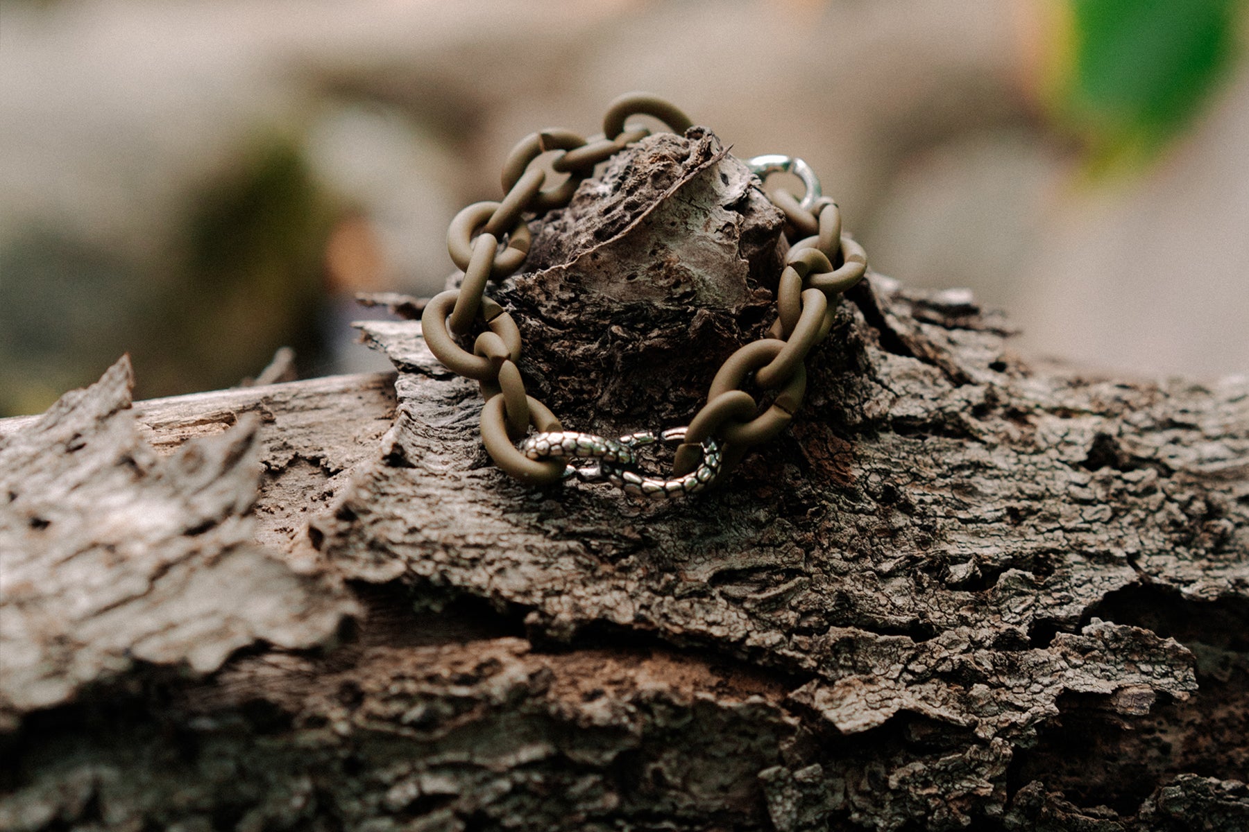 X Jewellery bracelet with a serpent link laying on the ground